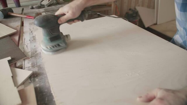 Carpenter uses a grinding machine to align