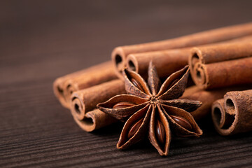 Anise star and cinnamon sticks on brown wooden table. Close up, isolated photo, copy space in the corner.