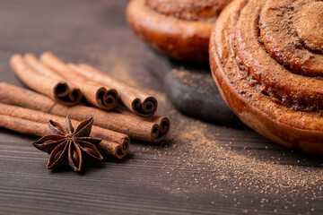 Close up shot of cinnamon sticks and anise star on the brown table. Bakery theme, aromatic condiments concept.