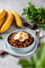 Chocolate oatmeal with banana in bowl for breakfast