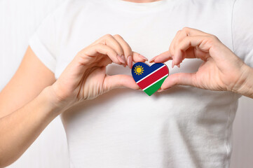 Flag of Namibia in the shape of a heart in the hands of a girl. Love Namibia. Respect for Namibians