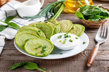 Pancakes with spinach and sour cream on a table. Gluten free spinach pancakes recipe