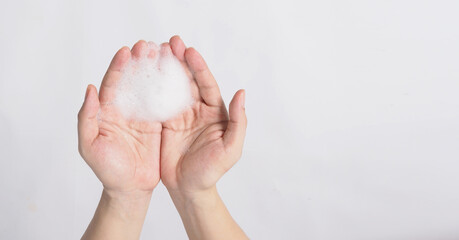 Hand washing gesture with foaming hand soap on white background.