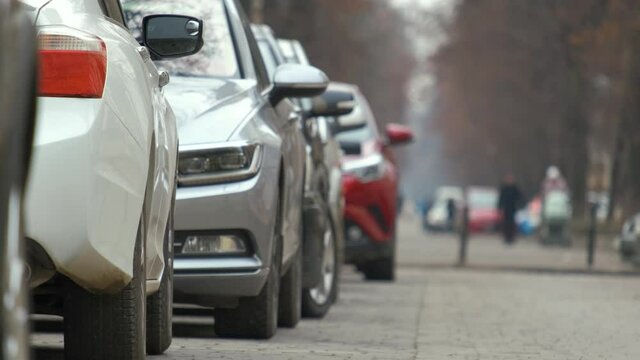 Cars parked in a row on a city street side.