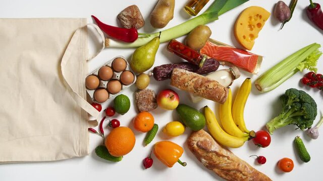 Grocery bag with fruits, vegetables, bread, bottled beverages. Vertical footage. Top View. Stop Motion