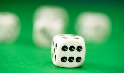 White dice on green felt table close up