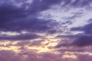 Naklejka na ściany i meble Sunset sky with clouds and sunbeams through wind clouds.