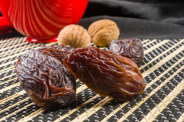 Big luxury dried date fruit on the bamboo mat, kurma ramadan kareem concept, close up.