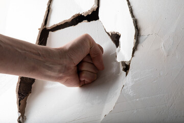 The angry man hits the wall and breaks it