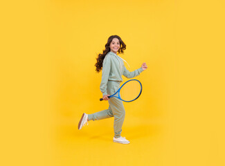 happy energetic kid jump in sportswear with tennis racket running to success, active childhood.