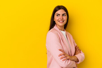 Obraz premium Young caucasian woman isolated on yellow background smiling confident with crossed arms.