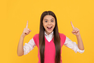 amazed teen school girl with long hair inspired with idea on yellow background, amazement