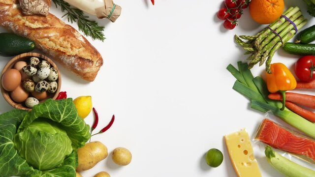 Healthy food background. Different fruits and vegetables on white background. Vertical footage. Top View. Stop Motion
