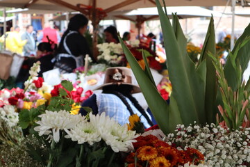 Colorful flower market in cuenca ecuador south america, indigenous women with braids selling colorful flowers in typical street market in south america