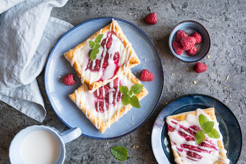 Danish pastry with cream cheese, raspberry and powdered sugar icing