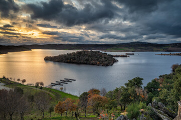 Obraz premium Wonderful sunset in Tras Os Montes, northern Portugal. Amazing landscape of Albufeira do Azibo. A huge lake with river beach and dock for pleasure boats. Postcard with panoramic view in the background