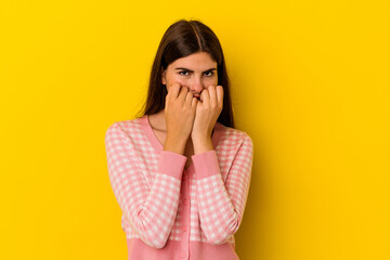 Young caucasian woman isolated on yellow background biting fingernails, nervous and very anxious.