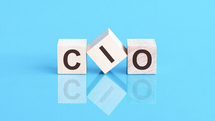 cio word is made of wooden building blocks lying on the blue table, concept - obrazy, fototapety, plakaty