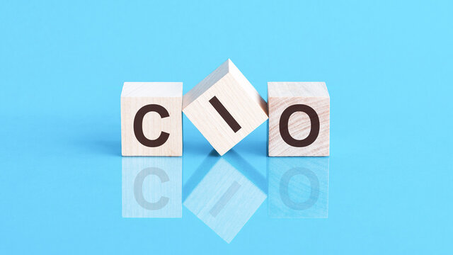 cio word is made of wooden building blocks lying on the blue table, concept