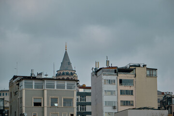 istanbul Turkey. Galata tower top and it is behind the old vintage apartments and overcast sky...