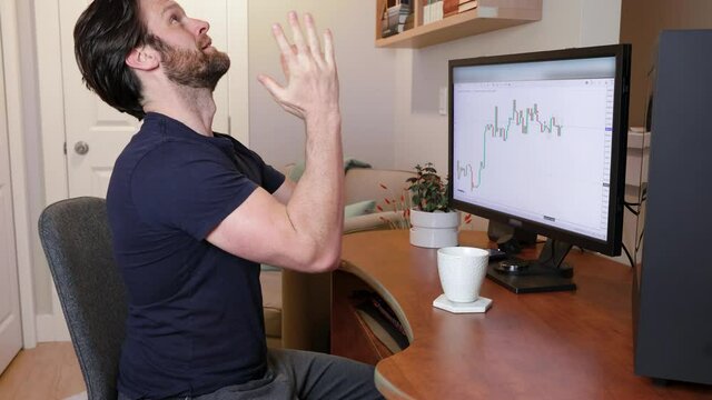 Man looking at finance chart on computer stressed out, praying and wishing for the market to go up and not crash. 4K 24FPS