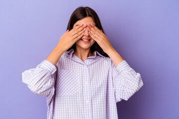 Young caucasian woman isolated on purple background afraid covering eyes with hands.