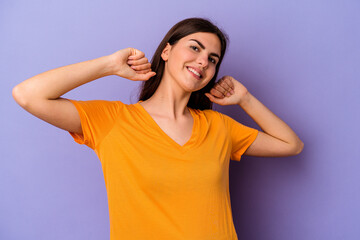 Young caucasian woman isolated on purple background stretching arms, relaxed position.