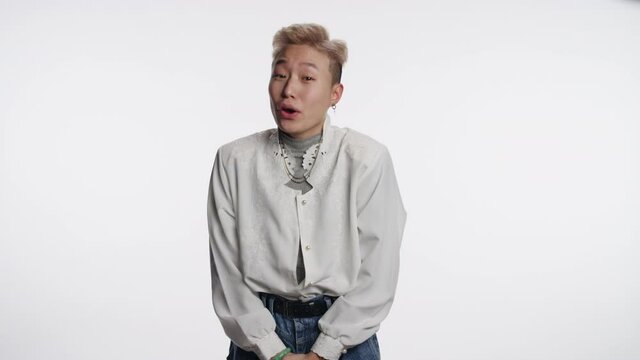 Portrait of a young Asian person laughing to mock someone speaking