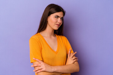 Obraz premium Young caucasian woman isolated on purple background suspicious, uncertain, examining you.