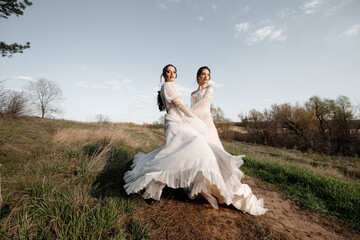 Fototapeta na wymiar Two beautiful brides in a light dress posing. Boho style.