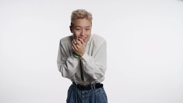 Asian person with striking features fake laughs at someone