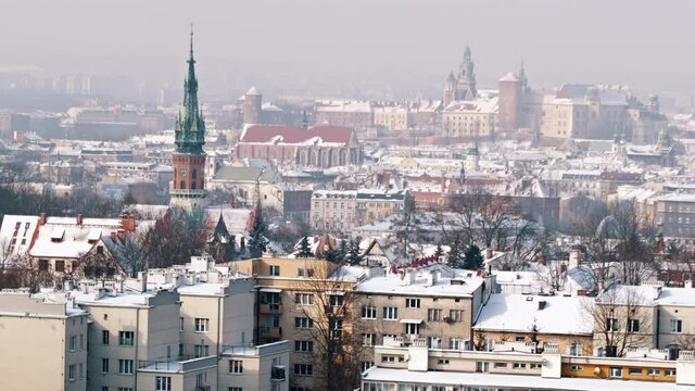 Slow-motion footage of Wawel Royal Castle from Krakus Mound, the highest point in the city of Krakow, Poland. Panoramic view of the City. Ancient buildings against the clear white sky in the