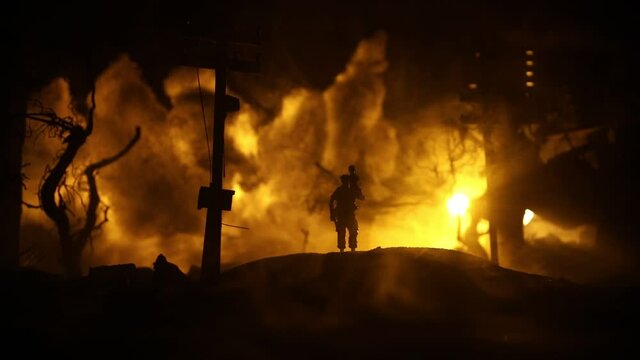 Silhouette soldier carrying little boy on his shoulder from fire. Rescue savior concept. Man moving out with little boy from burned out city destroyed in war. Selective focus
