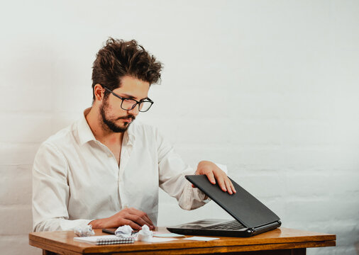 Latino Young Man Closing Notebook. Tiredness After A Long Day's Work. Work At Home Concept. Copy Space