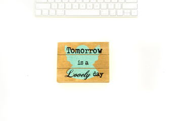 stylish flat lay: motivational phrase and modern keyboard on white office desk