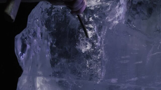 Beautiful ice sculpture being created with a chisel by a professional artist, 4k