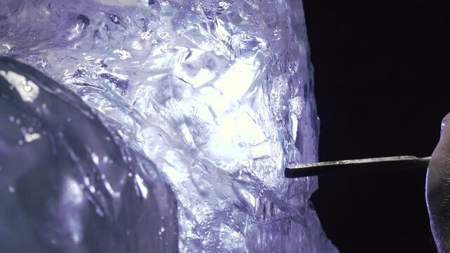 Shaping big block of ice into a sculpture using a chisel and hammer, 4k