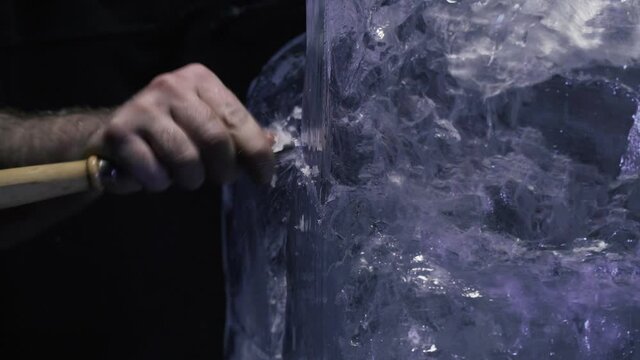 Shaping an ice sculpture using a chisel, professional artist at work, 4k