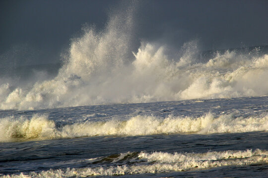 Storm at sea with strong winds, high splashing waves, and a dark sky