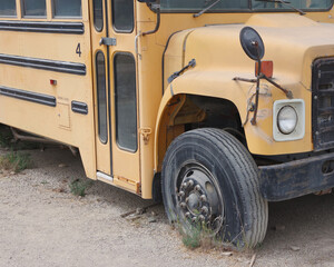 Old decommissioned school bus with a flat tire