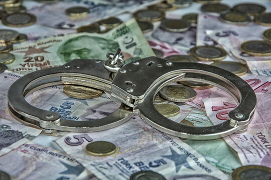Handcuffs on the paper money in close-up on the screen covered with paper money