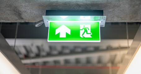 Emergency fire exit sign show the way to escape at the public area, warehouse store, For the security first about the being fire concept..
