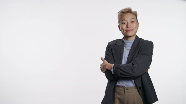 Cool and confident Asian person poses next to white graphic space