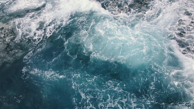 Vitality of blue energy and clear ocean water. Powerful stormy sea waves in top-down drone shot perspective. Crashing wave line in Open Atlantic sea with foamy white texture.

