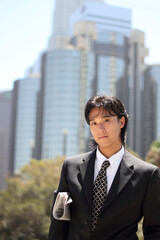 Young Japanese businessman walking in the american business district	
