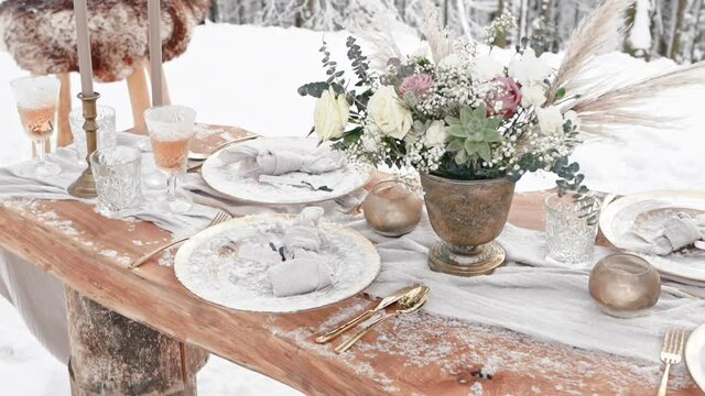 Decorated table for luxury wedding arranged outside in snowy winter forest
