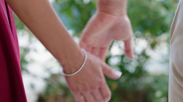 Up close view of couple reaching to hold hands