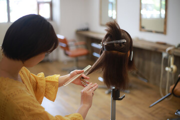 髪を切る練習する美容師　イメージ