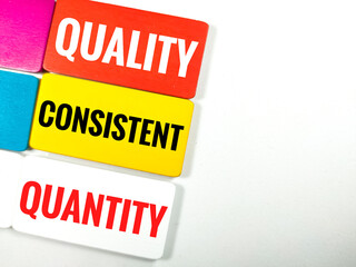 Business concept.Wooden board with text quality,consistent,quantity on white background.