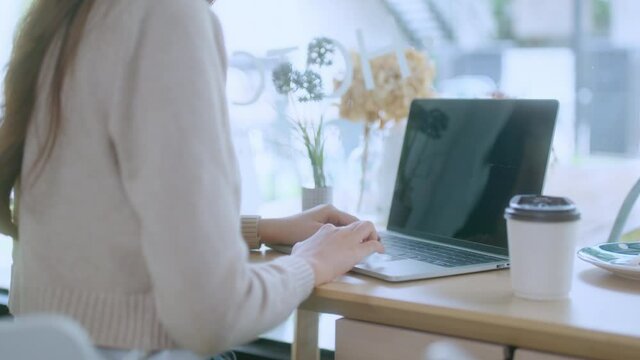 young attractive asian female wear casual cloth hand use smartphone and laptop device comminication social contact in cafe restaruant sit at counter next to big window daylight